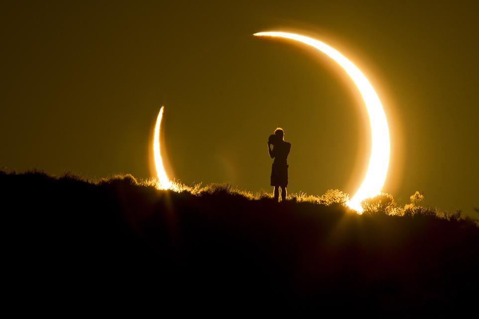 Natural World An Onlooker Witnesses the Annular Solar Eclipse as the Sun Sets on May 20, 2012 Colleen Pinski